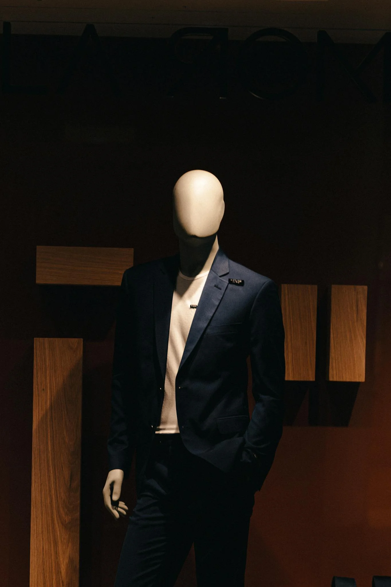 Stylish mannequin in a formal suit in low light, ideal for fashion and retail themes.